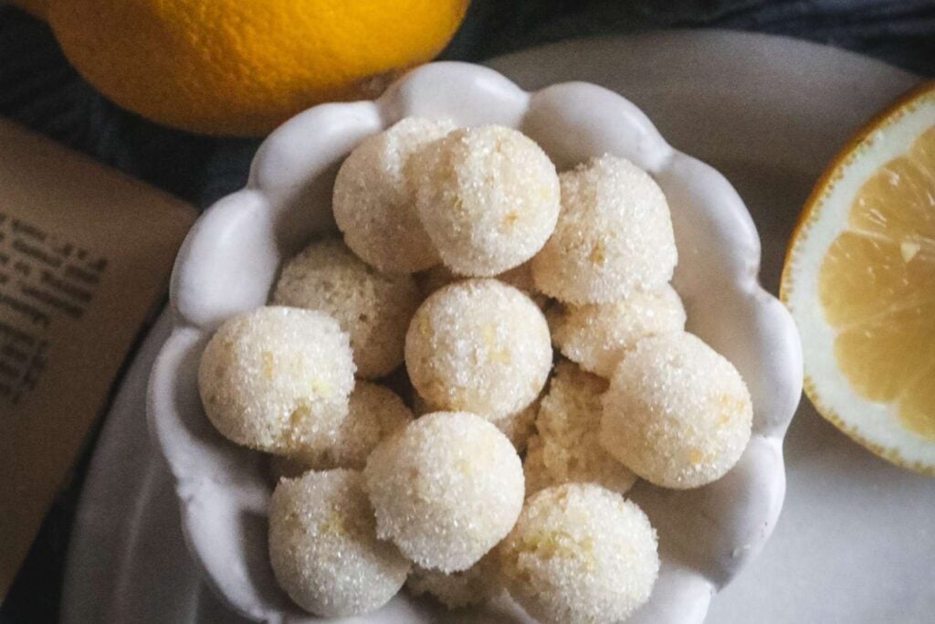 overhead view of a white scalloped bowl filled with homemade lemon sugar cubes.