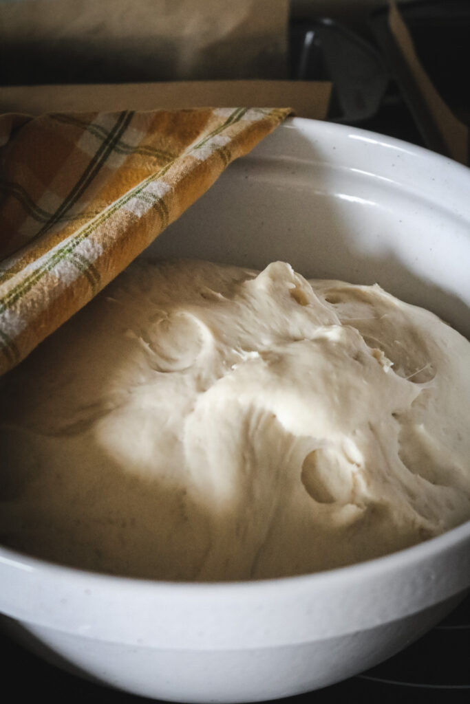 large mixing bowl with bread dough doubled and ready for shaping.