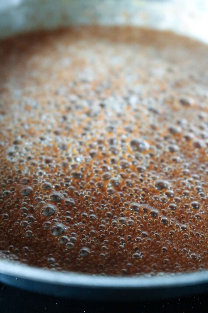close up view of finished brown butter studded with lots of brown bits from adding milk powder.