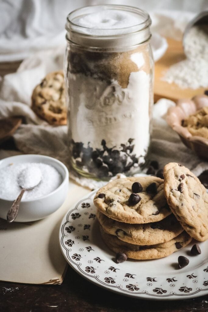 a plate of homemade chocolate chip cookies in front of a quart mason jar with homemade chocolate chip cookie mix.