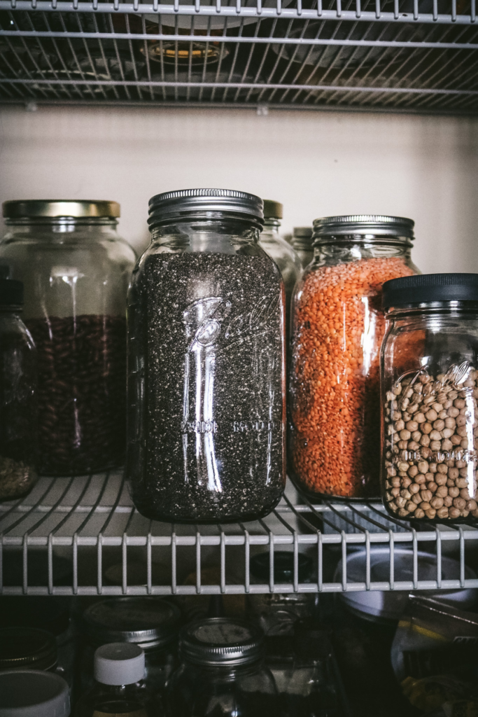 jars of dried beans, chia seeds, and lentils in a homestead pantry.
