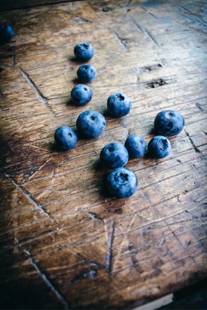 handful of fresh blueberries on a wooden table.