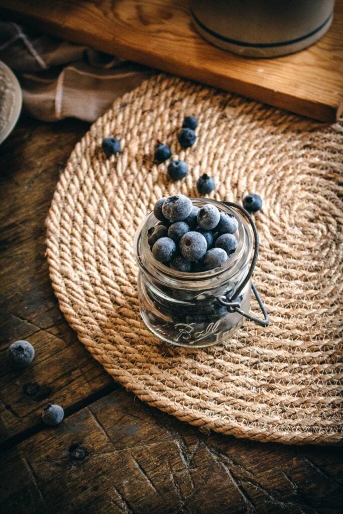 vintage jar with frozen blueberries fresh picked from a local farm.