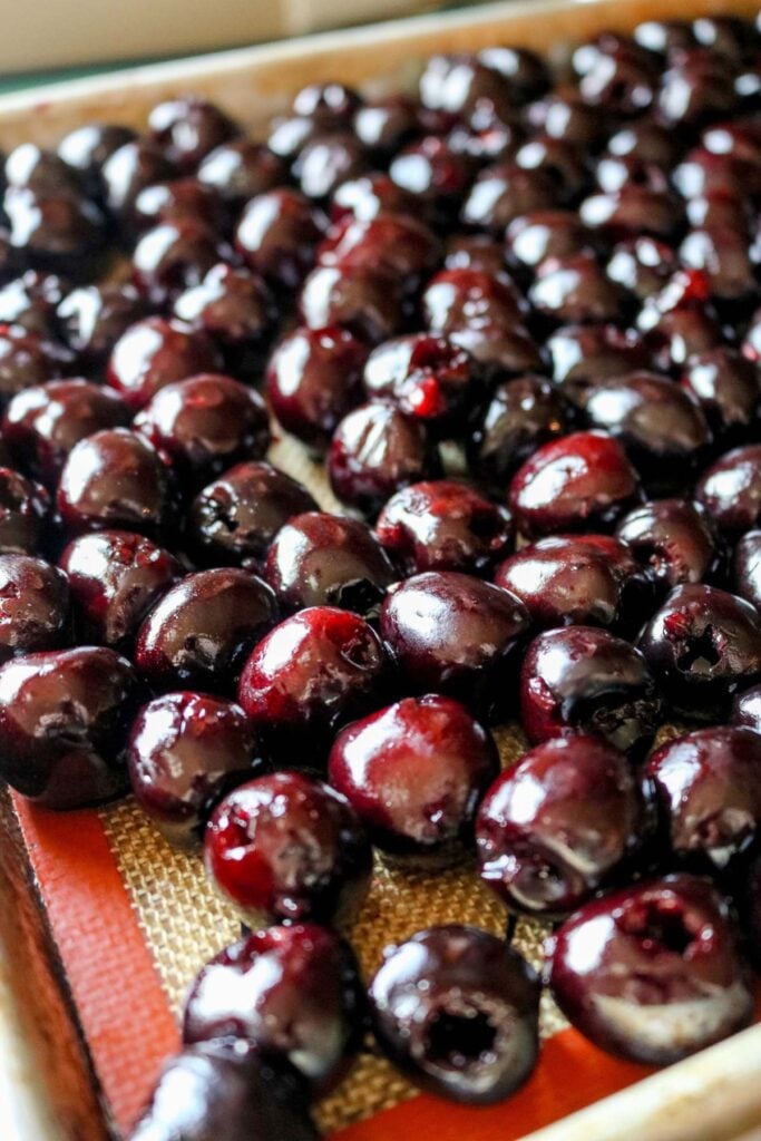 pitted cherries on a sheet pan.