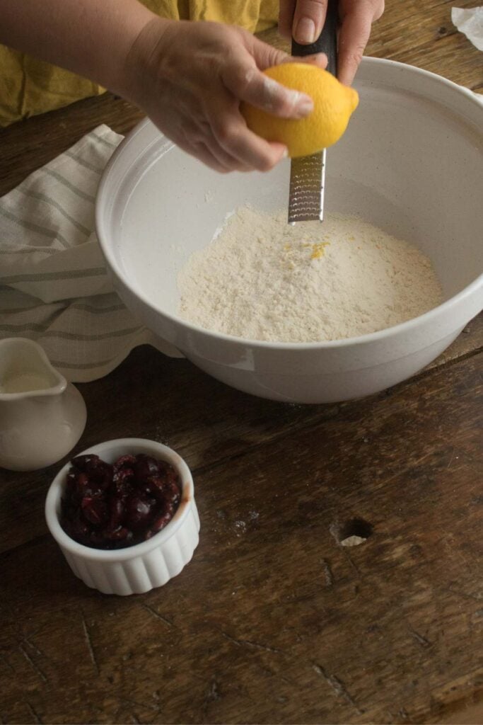 zesting lemon into cherry scone dough.