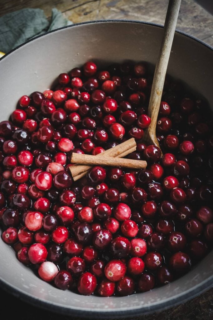 cranberries and cinnamon sticks in a dutch oven.