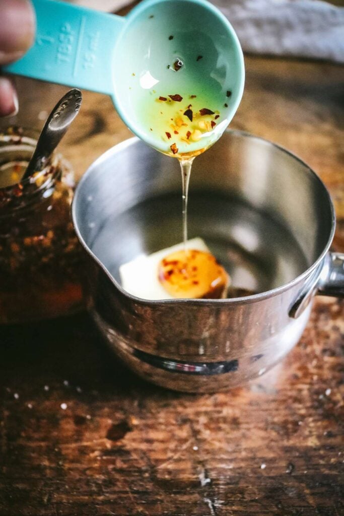 drizzling hot honey over butter in a sauce pan.