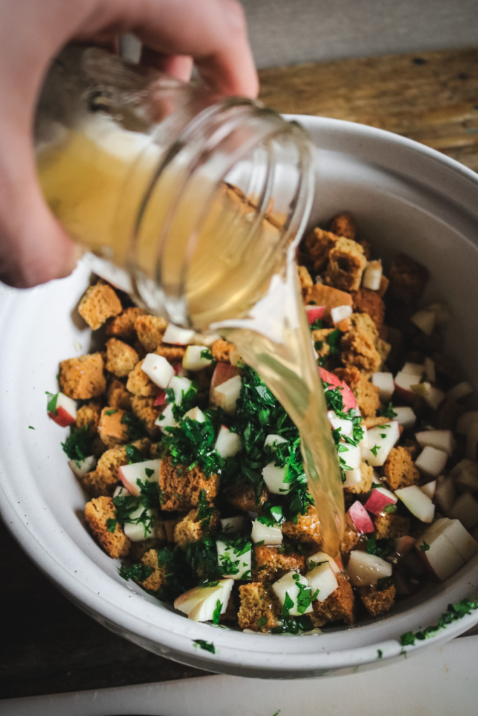 adding chicken stock to sourdough cornbread stuffing.