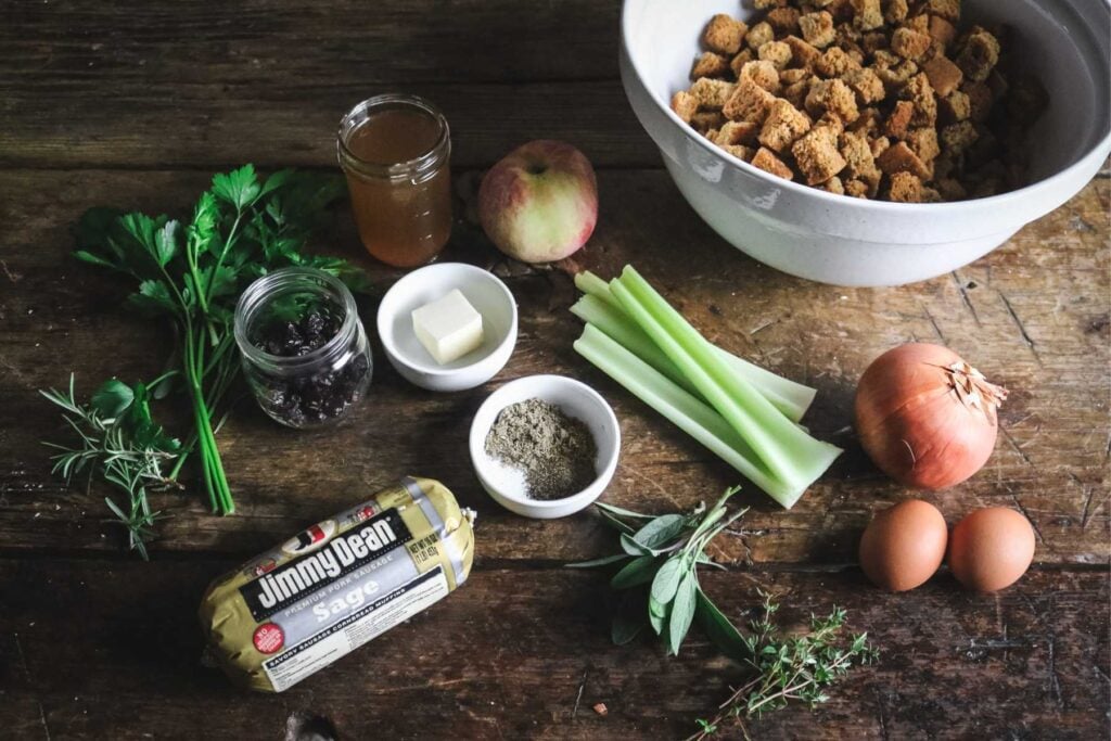 ingredients to make sourdough cornbread sausage stuffing on a wooden table.