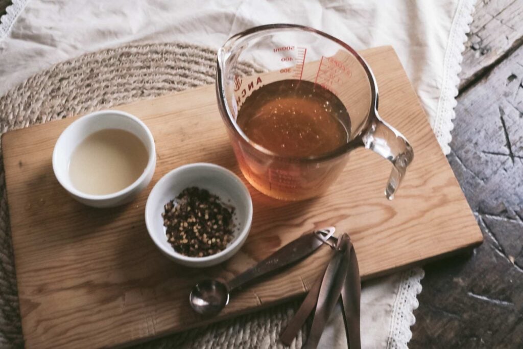 ingredients to make hot honey on a wooden cutting board.