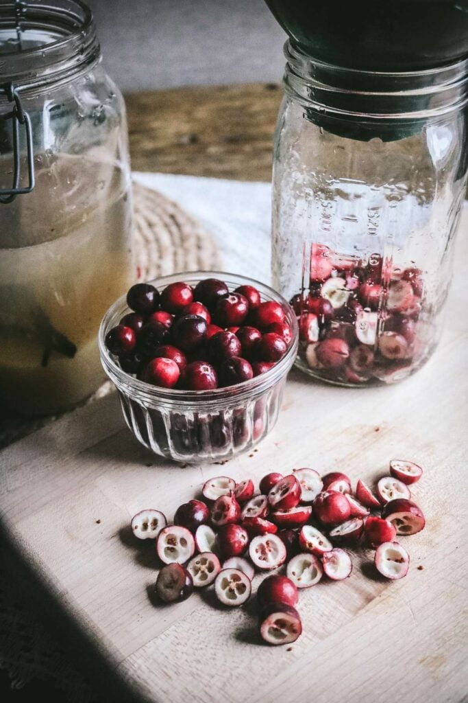 halved cranberries on a cutting board.