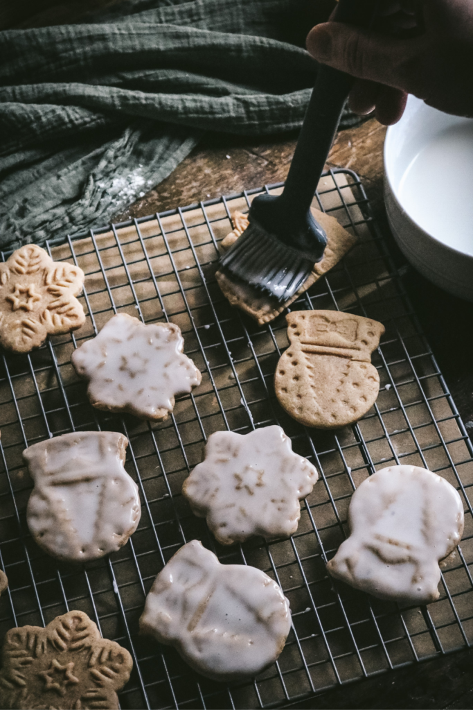 brushing homemade honey gingerbread cookies with glaze.