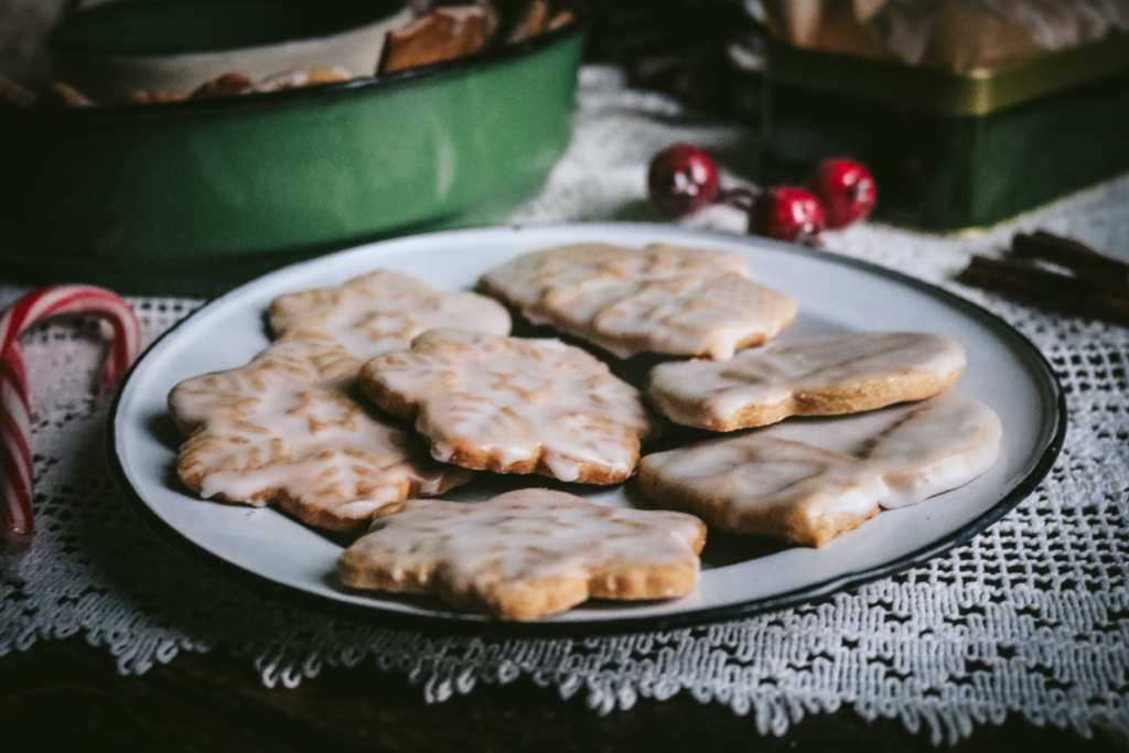 vintage enamel tray with homemade honey gingerbread next to candy canes and ornaments.