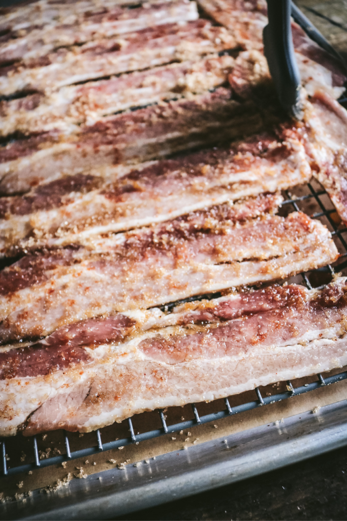 brushing bacon with brown sugar.