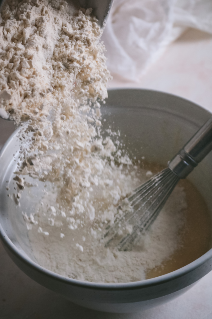 adding the dry ingredients to the wet ingredients for strawberry white chocolate muffins.