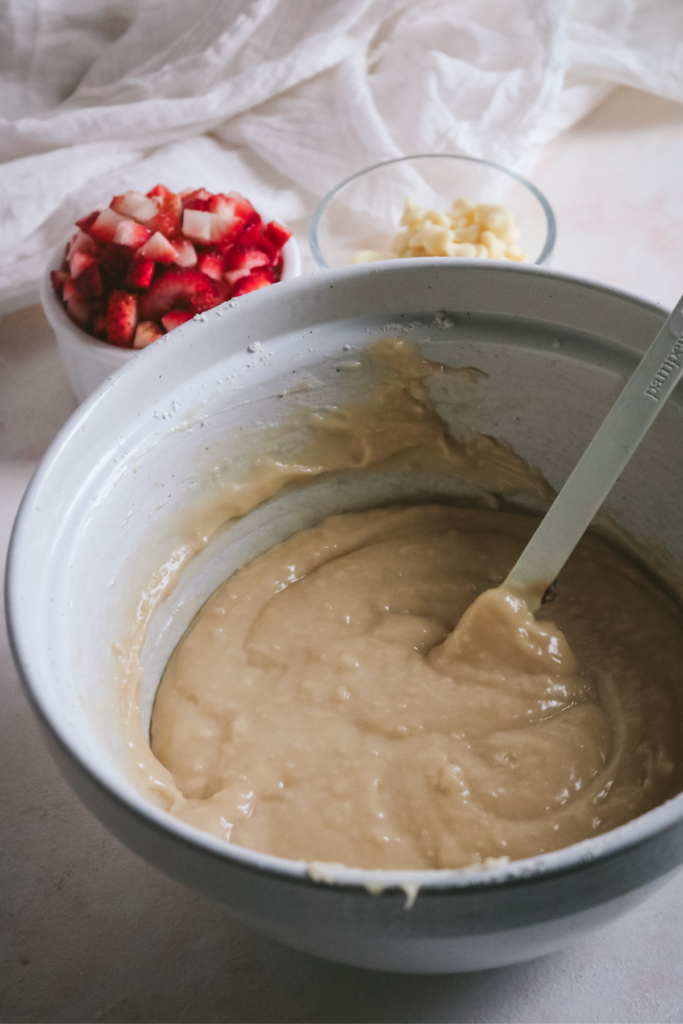stirring the muffin batter for white chocolate and strawberry muffins.