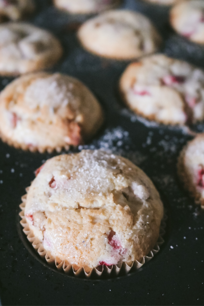 close up view of strawberry white chocolate muffins in a baking pan.