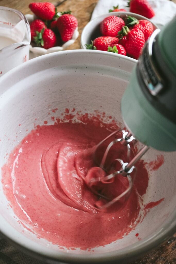 whisking strawberry puree and heavy cream for strawberry whipped cream.
