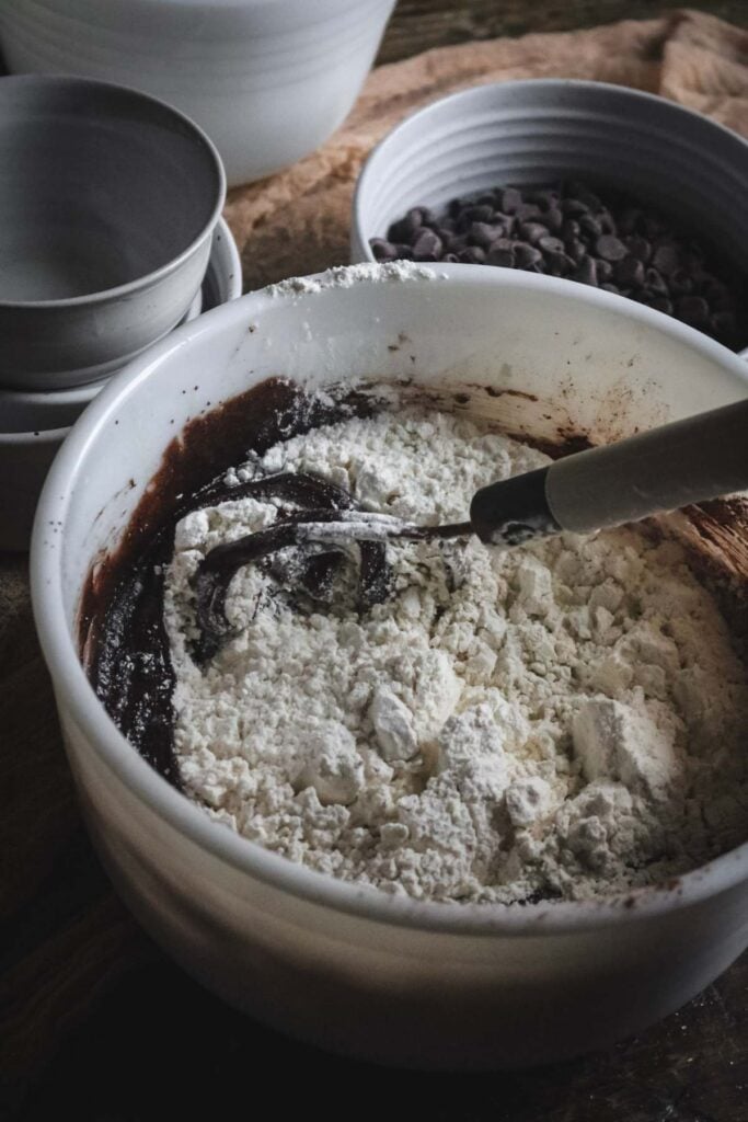 whisking flour into double chocolate cookie bar dough.