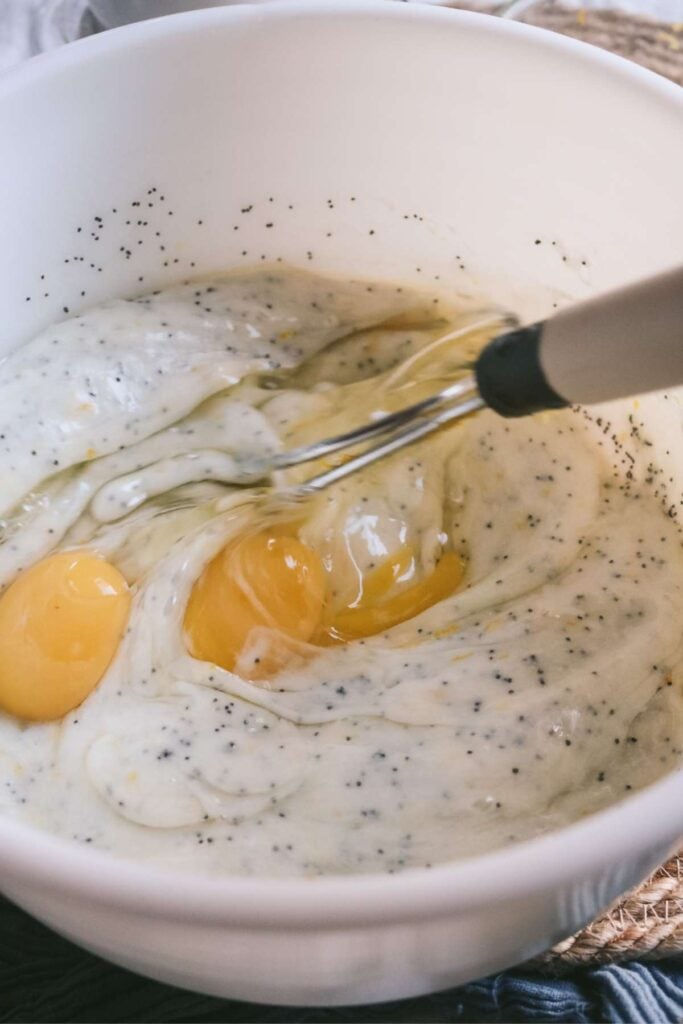 adding eggs to lemon and poppyseed muffin batter.