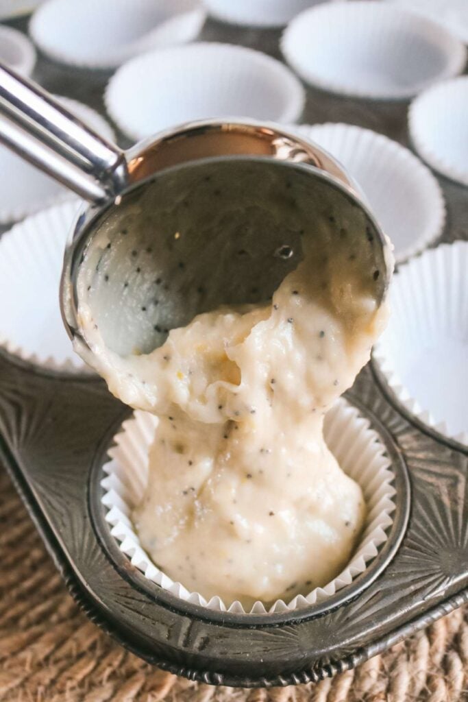 adding lemon poppyseed muffin batter to muffin liners.