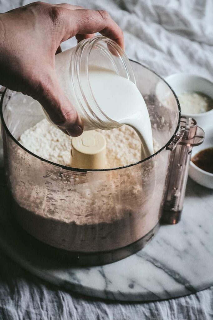 adding heavy cream to the food processor for vanilla scones.