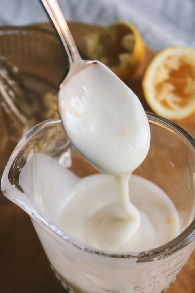 drizzling easy lemon glaze into a glass container.
