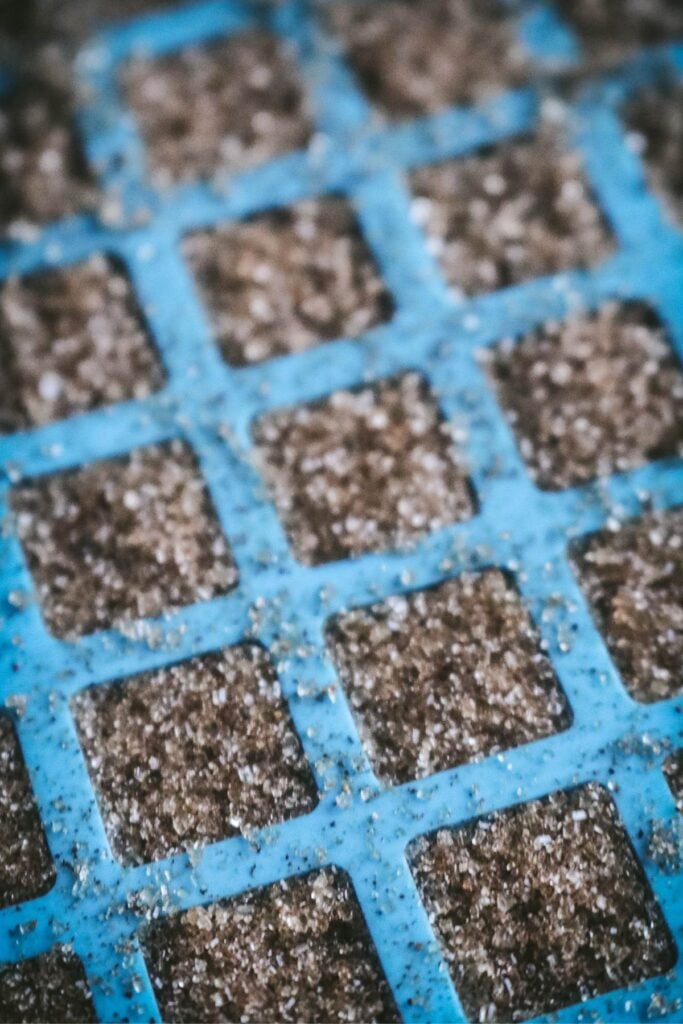 close up view of homemade brown sugar sugar cubes in a blue silicone tray.