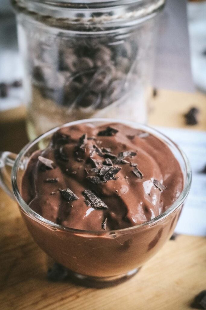 glass mug with rich and creamy chocolate pudding made with a dry mix including chocolate chips and cocoa powder.