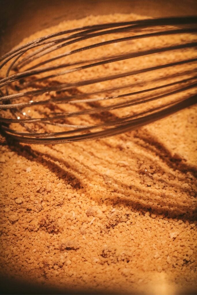 combining brown sugar, cornstarch, and salt in a pot with a whisk to make butterscotch pudding.