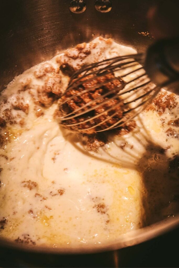 whisking milk into a melted mixture of brown sugar and butter for homemade butterscotch pudding.