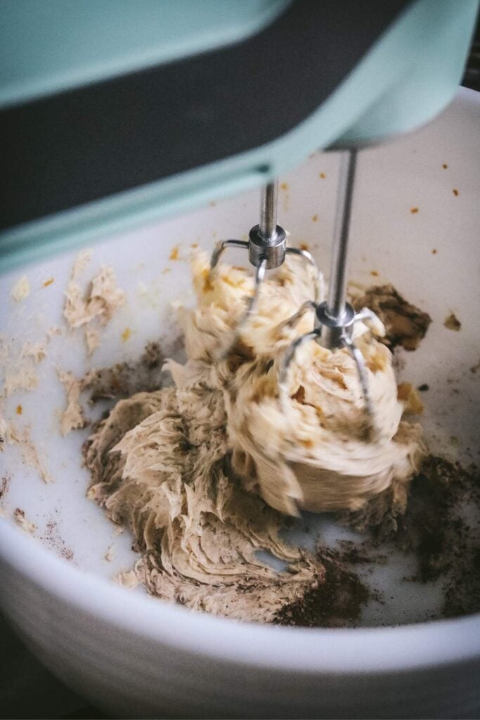 whipping butter, orange zest, and spices in a bowl with a hand mixer.
