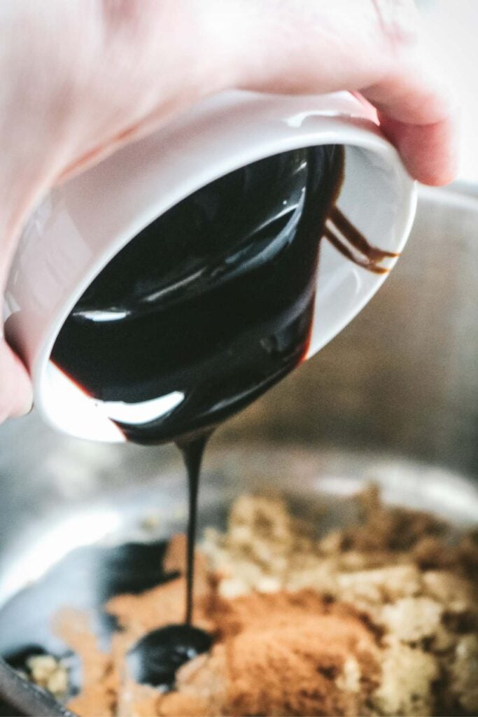 pouring molasses into a pan to make gingerbread coffee creamer.