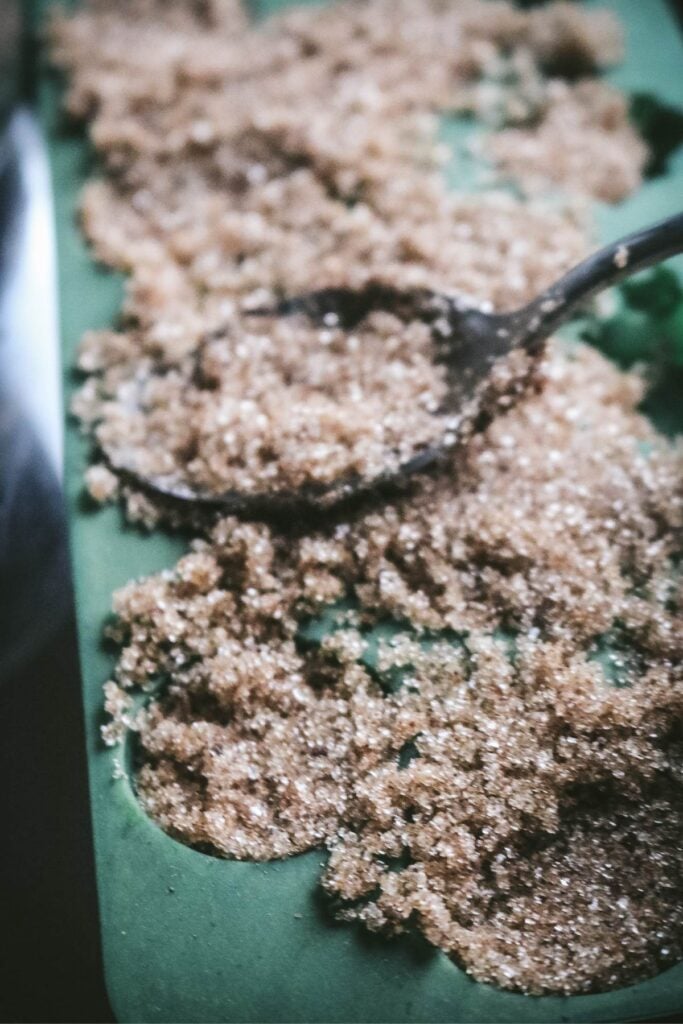 pressing down on damp sugar mixture to make sugar cubes for christmas.