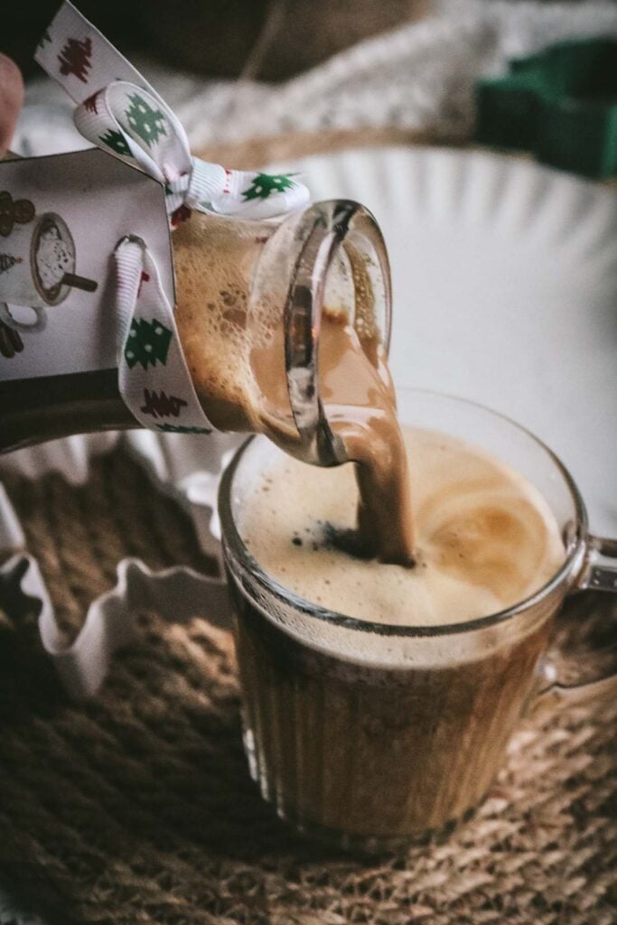 pouring gingerbread creamer into a cup of coffee.