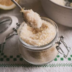 glass jar with homemade lemon sugar and a spoon heaped with the sugar.