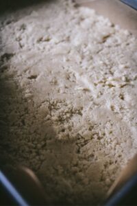 a 9x13 baking pan with the shortbread crust prepped for chilling.