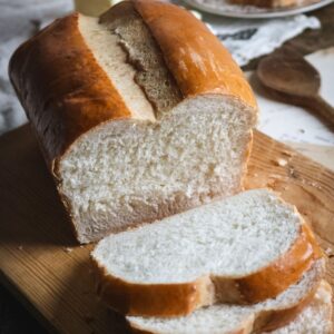close up view of a loaf of homemade white sandwich bread with a super soft and light texture.